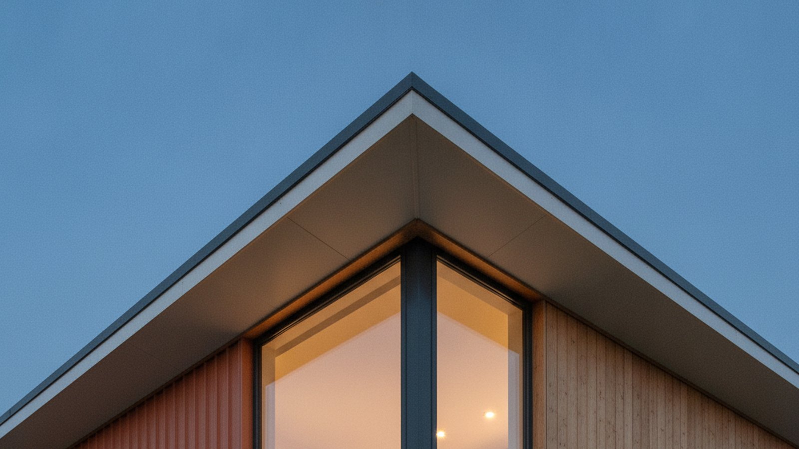 Angle d'une maison container contemporaine au crépuscule, bardage métallique et bois